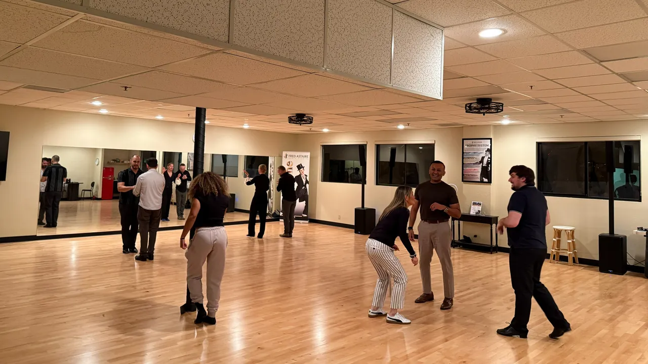 Adults practice salsa timing together in the studio.